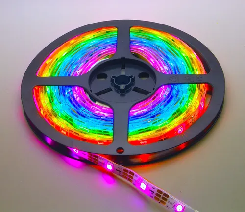 Digitaler LED RGB NeoPixel Stripe - 5m Rolle, IP65 Spritzwassergeschützt - LED-Lampe mit 30 LEDs/m, selbstklebend und ideal für kreative Projekte. Der WS2812B Chipsatz ermöglicht individuelle Farbsteuerung über Mikrocontroller.